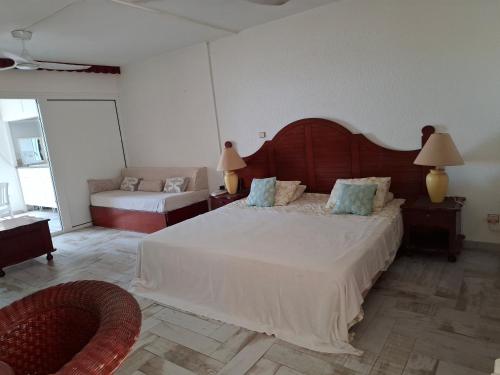 a bedroom with a large bed and a couch at Just in paradise in Baie Nettle