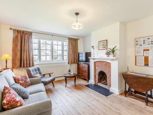a living room with a couch and a fireplace at Mark Farmhouse in Bradwell on Sea