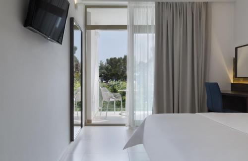 a hotel room with a bed and a sliding glass door at Bluesun Hotel Alga in Tučepi