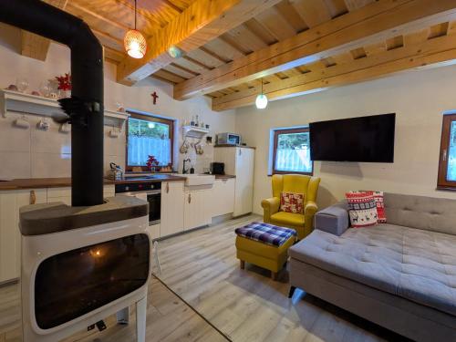 a kitchen and living room with a stove at Jariabka Chalet - sun terace, fireplace, grill, space to play, green embrace of the forest in the Low Tatras in Jarabá