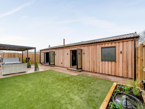 a backyard with a wooden house with a lawn at The Workshop - Uk42470 in Middleton
