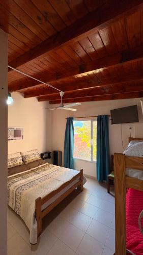 a bedroom with a large bed and a window at Hostel Maranata in Puerto Madryn