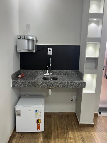 a kitchen counter with a sink and a box at Casa Lua Flat in Brumadinho