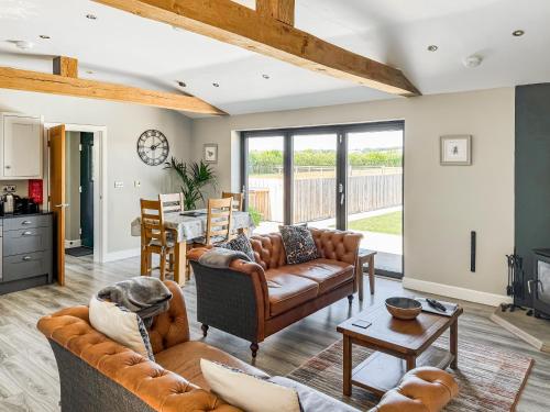 a living room with two couches and a table at The Old Dairy - Uk31253 in Middleton