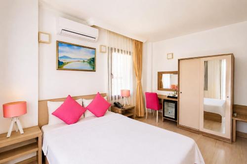 a bedroom with a white bed with pink pillows at Aria Doria Otel in Datca
