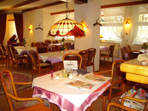 a restaurant with tables and chairs and a chandelier at Hotel an der Hauptallee in Bad Pyrmont