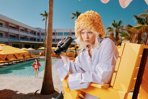 a woman sitting on a bench with a camera at Los Felices Ibiza in San Antonio Bay