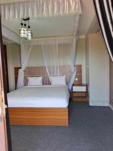 a bedroom with a white bed with a canopy at Masese Heights in Jinja