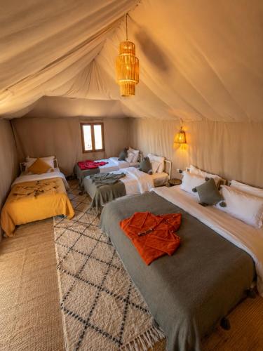 a room with four beds in a tent at Rosara Luxury Camp in Merzouga