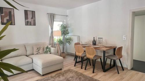 a living room with a table and a couch at Stilvolles Apartment im Siebengebirge in Königswinter
