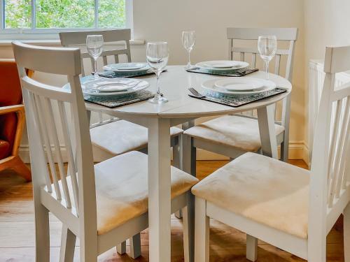 a white dining room table and chairs with wine glasses at Solara Breeze in Filey