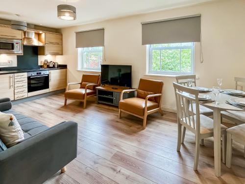 a kitchen and living room with a table and chairs at Solara Breeze in Filey