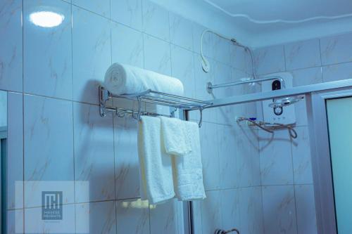 a bathroom with white towels and a shower at Masese Heights in Jinja