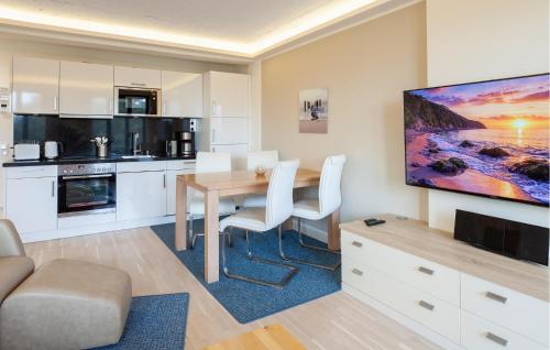 a kitchen with a dining table and a tv on a wall at Princess in Binz