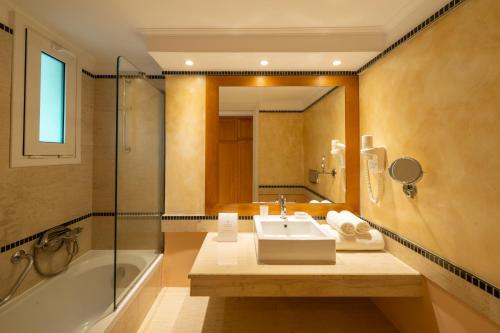 a bathroom with a sink and a shower and a tub at Mitsis Ramira in Kos
