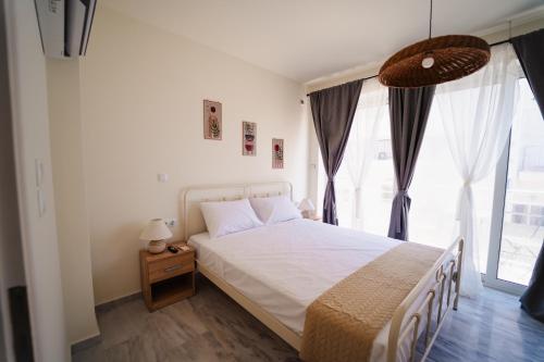 a bedroom with a bed and a large window at Zoe Apartment Port View Β in Rafina