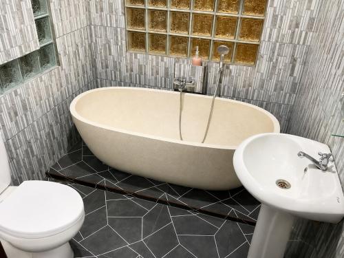 a bathroom with a tub and a toilet and a sink at Bendul Retreat in Tabanan