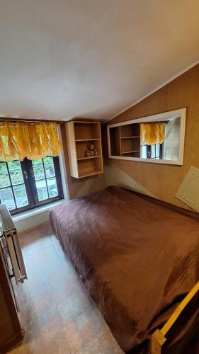 a large bed in a bedroom with two windows at Jūrmala beach in Jūrmala
