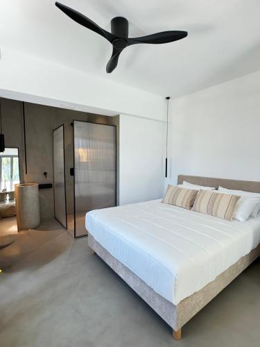 a bedroom with a white bed and a ceiling fan at Almond Chambers in Naousa
