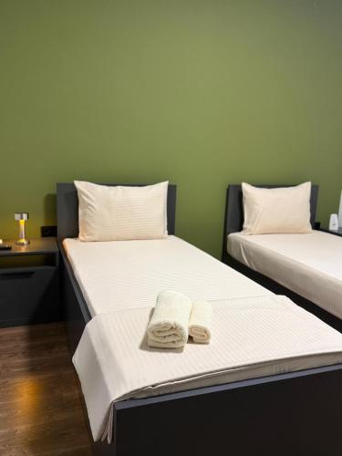 two beds with towels on them in a room at Ajazi Rooms in Struga