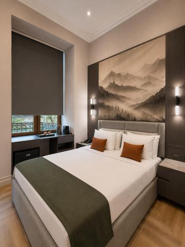 a bedroom with a large bed with a painting on the wall at Amara Boutique in Baku
