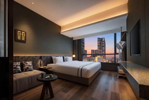 a hotel room with a bed and a large window at YOUNG Hotel Guilin -Mixc Mall in Guilin