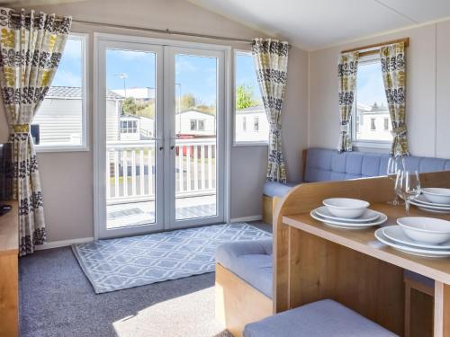 a living room with a table and chairs and a balcony at The Hideaway - Uk49292 in Morecambe