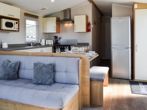a kitchen with a blue couch in a kitchen at The Hideaway - Uk49292 in Morecambe