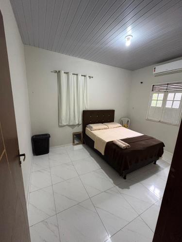 a bedroom with a bed in the middle of a room at Casa Completa no Centro de Soure com Wi fi e Garagem in Soure