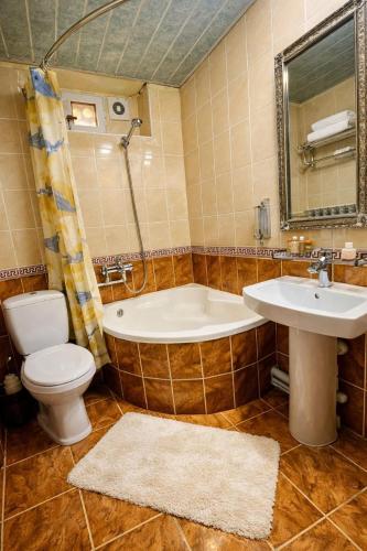 a bathroom with a tub and a toilet and a sink at Hotel Chorminor 110 m to Old Town GET EARLY CHECK IN AND CHECK OUT in Bukhara
