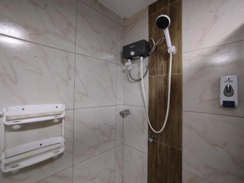 a bathroom with a shower with a phone on the wall at Apartamentos "APPART D'ELIETTE" in Trujillo