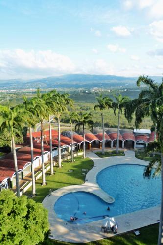 a resort with a swimming pool and palm trees at Hotel Jirahara in Barquisimito