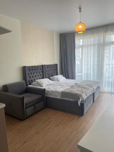 a bedroom with a large bed and a couch at у моря in Batumi
