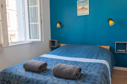 a blue bedroom with a bed with two towels on it at Le petit baigneur, 300m de la mer et centre ville in Étretat