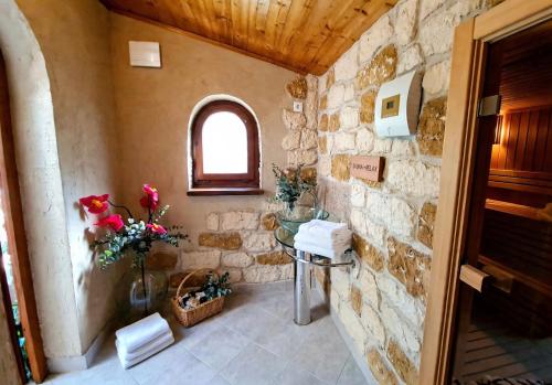 a stone bathroom with a sink and a window at Villa Stone House Poplat in Vela Luka