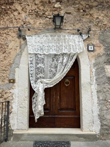 a curtain on the door of a stone building at Nido Stellato in Calascio
