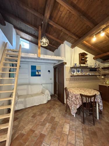 a room with a table and a bed and a staircase at Nido Stellato in Calascio