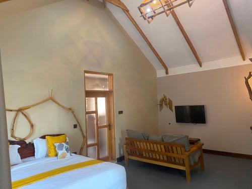 a bedroom with a large bed and a tv at Osinoni Cottages in Isiolo