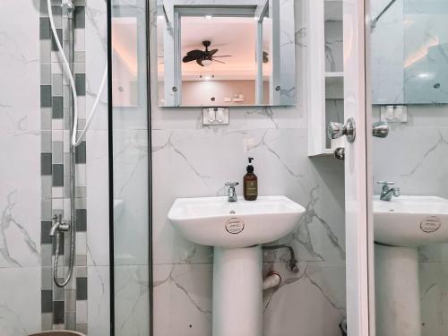 a bathroom with a sink and a glass shower at 1BR Apartment Beach Getaway Perfect for Couples in Bangcusay