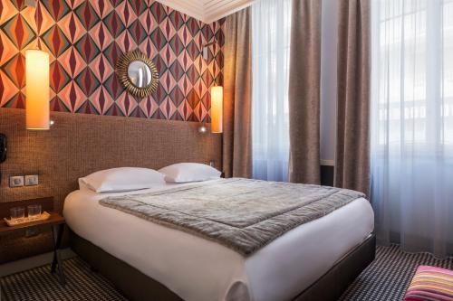 ein Schlafzimmer mit einem großen Bett in einem Zimmer in der Unterkunft Hotel Maison Lia in Châlons-en-Champagne
