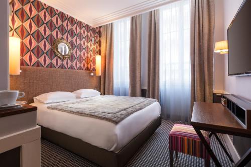 ein Hotelzimmer mit Bett und Fernseher in der Unterkunft Hotel Maison Lia in Châlons-en-Champagne