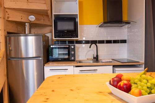 a kitchen with a bowl of fruit on a table at Le grand bleu, 300m de la mer et centre ville in Étretat