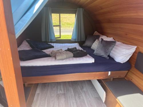 a bed in a tent with pillows on it at Claashoff Übernachtungsfass in Hollern-Twielenfleth