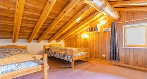 a bedroom with two beds in a wooden cabin at Chalet le Vernès Marmotte in Bonneval-sur-Arc