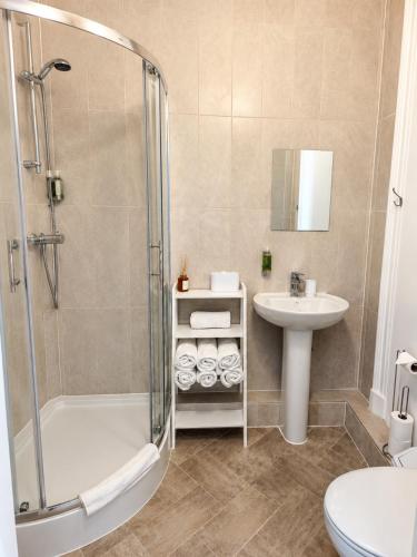 a bathroom with a shower and a sink at Tregonholme Hotel in Bournemouth