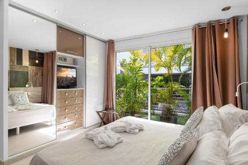 a bedroom with a bed and a large window at Hôtel Baie des Anges in Gustavia