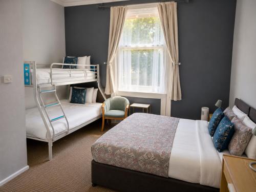 a bedroom with a bunk bed and a chair at Tregonholme Hotel in Bournemouth