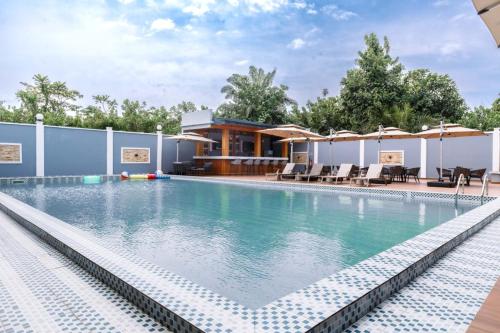a pool at a hotel with chairs and umbrellas at Logements Majeo in Kribi