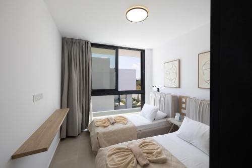 a hotel room with two beds and a window at Ocean Whispers Villas in Paralimni