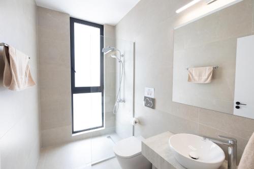a white bathroom with a sink and a toilet at Ocean Whispers Villas in Paralimni